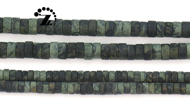 May include: Strands of dark green and black rectangular beads. The beads have a marbled appearance, with variations in color and texture. The beads are strung together, creating a necklace or bracelet.