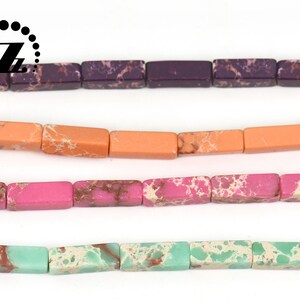 May include: Four strands of rectangular beads in various colors: purple, orange, pink, and turquoise. Each bead has a speckled pattern. The beads are strung together, ready for jewelry making.