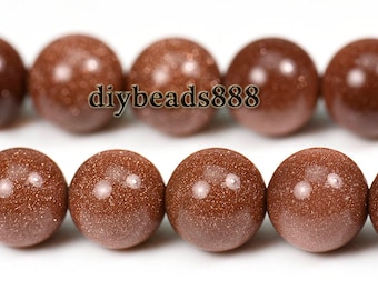 May include: A strand of brown sandstone beads with a speckled texture. The beads are round and have a smooth, polished finish. The beads are strung on a clear thread and are ready to be used for jewellery making.