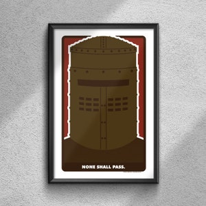 May include: A framed print with a brown illustration of a knight's helmet. The helmet has a visor and a series of small circles around the top. The background is red and the text "NONE SHALL PASS." is at the bottom of the print.