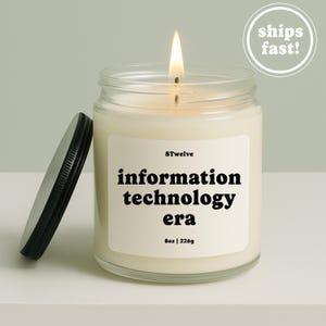 Peut inclure: Une bougie en pot de verre transparent avec une mèche allumée, dotée d'une étiquette crème portant le texte noir 8Twelve, information technology era, et 8oz | 226g. Un couvercle en métal noir repose à gauche de la bougie, contenant de la cire blanc cassé.