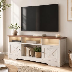 May include: A white media console with a brown wooden top, featuring two side cabinets with X-shaped door panels, three open storage shelves with integrated warm lighting, and black round knobs, positioned beneath a large flat-screen television.