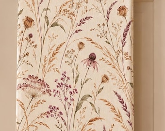 May include: A rectangular kitchen towel featuring a cream-colored background with a botanical print of dried wildflowers, grasses, and seed heads in shades of muted purple, brown, gold, and green, hanging from a brass-toned metal towel bar.