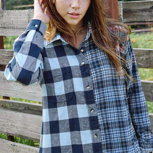 Può includere: Una camicia a maniche lunghe con bottoni dal design diviso. Il lato sinistro presenta un grande motivo a quadri buffalo neri e azzurri, mentre il lato destro mostra un motivo scozzese più piccolo nei toni del blu, nero e bianco.