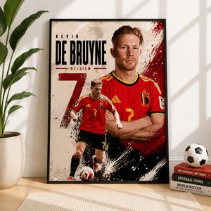 May include: A framed poster featuring a graphic illustration of footballer Kevin De Bruyne in a red and black Belgium kit. The design includes the text KEVIN DE BRUYNE BELGIUM and the number 7, with a large portrait and a full-body action shot.