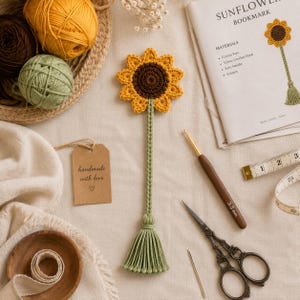 Può includere: Un segnalibro all'uncinetto a forma di girasole con centro marrone scuro e petali gialli, attaccato a un lungo stelo verde con una nappa finale. Sono presenti un uncinetto da 3,5 mm, forbici, un metro a nastro e gomitoli di filato.