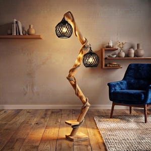 May include: A floor lamp featuring a vertical, twisted wooden post wrapped in thick rope. Two black, spherical, wire-mesh shades are attached to the post, each containing a glowing light bulb. A small wooden shelf is attached near the base.