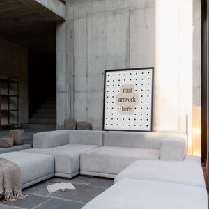 May include: A rectangular framed poster featuring a white background with a black grid of dots and a central beige shape containing the black text "Your artwork here". The frame is black and thin, positioned against a concrete wall.
