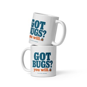 May include: Two white ceramic mugs stacked vertically. The mugs feature the blue text "GOT BUGS?" above the orange text "you will." and a small orange ladybug illustration. Below this, the text "TECH SUPPORT ANONYMOUS" is printed in small letters.