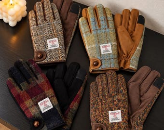 Könnte beinhalten: Vier Paar Handschuhe aus Harris-Tweed-Stoff mit Fischgrät-, Karomustern und Sprenkeln. Jedes Paar verfügt über einen braunen Knopf am Handgelenk, ein Harris-Tweed-Etikett und einfarbige, wildlederartige Handflächen mit schwarzen Fingerspitzen.