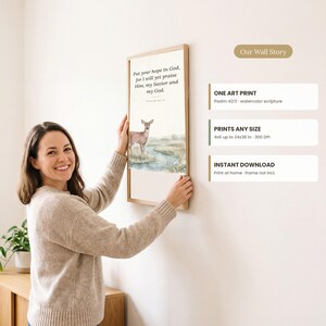 Könnte beinhalten: Ein rechteckiger Kunstdruck in einem hellen Holzrahmen mit einer Aquarellillustration eines Hirsches an einem Bach. Der Text lautet: Put your hope in God, for I will yet praise Him, my Savior and my God. Psalm 42:11.