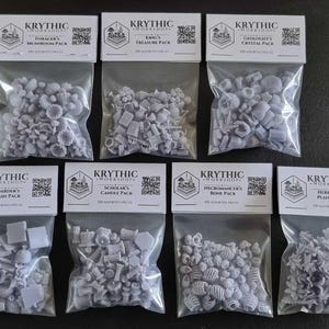 May include: Seven clear plastic bags containing small, light grey resin miniature pieces. Each bag has a white header card labelled Krythic Workshop with titles including Forager's Mushroom, King's Treasure, Geologist's Crystal, Hoarder's Trash, Scholar's Candle, Necromancer's Bone, and Herbalist's Plant pack.
