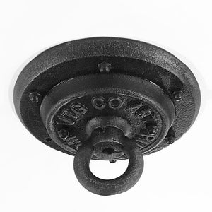 May include: A black, industrial-style ceiling canopy with a circular design. It features a central ring for hanging and is secured with multiple bolts. The surface has a textured, cast-iron appearance, with the text "TG CO" visible.