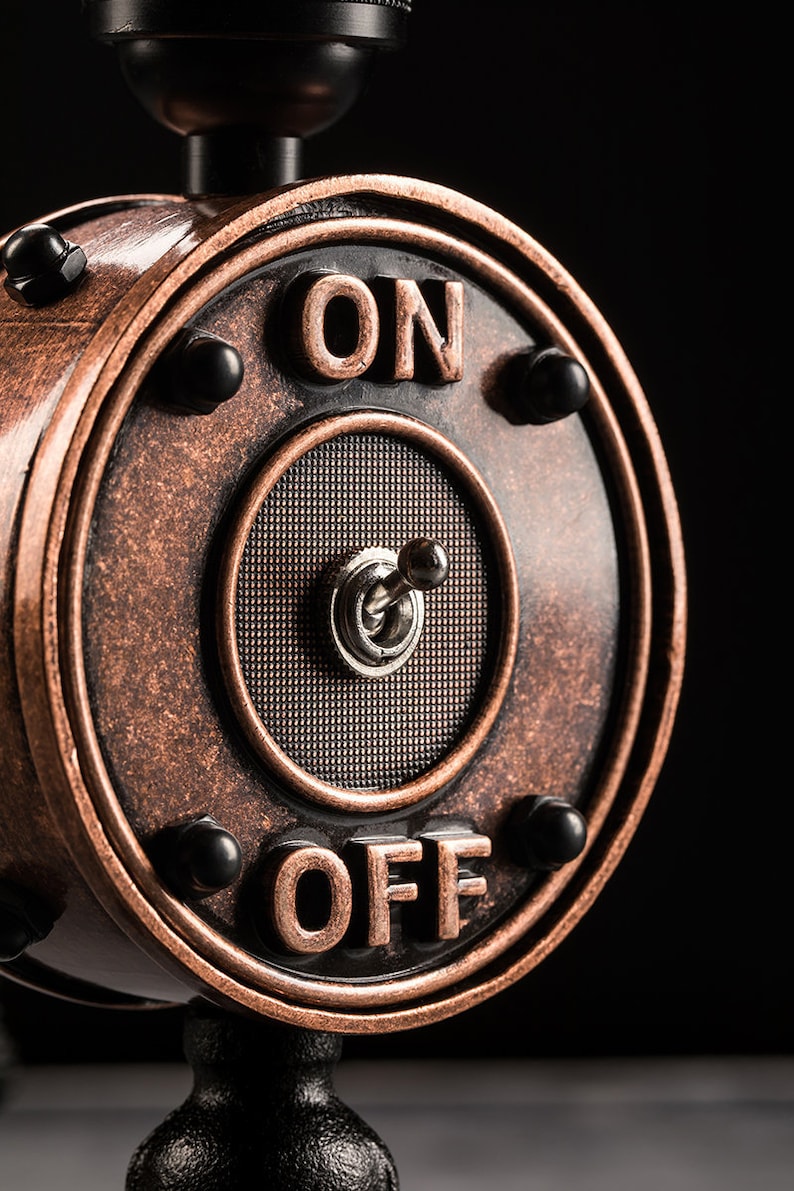 May include: A vintage-style copper-colored light switch with a black toggle switch. The switch is labeled "ON" and "OFF" in black lettering.