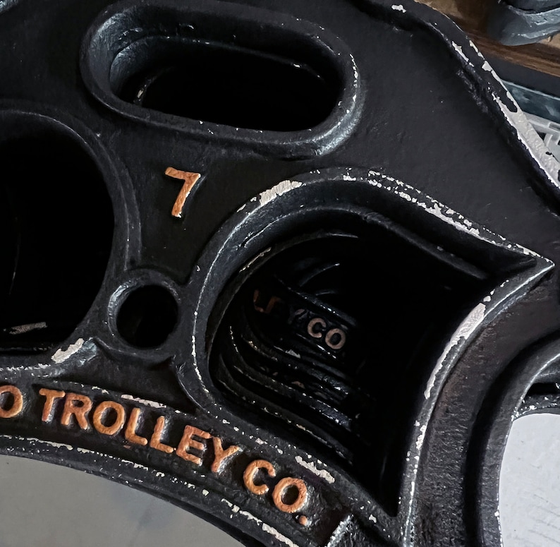 May include: A black metal trolley wheel with the number 7 and the text "O Trolley Co." in gold lettering.