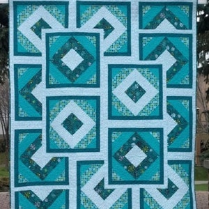 Puede incluir: Una colcha de color turquesa y blanco con un patrón geométrico. La colcha está colgada de un arco de metal.