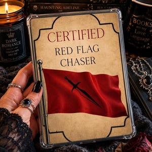 May include: A clear protective tablet or e-reader case featuring a vintage-style parchment background with the text CERTIFIED RED FLAG CHASER in black and red lettering, accompanied by an illustration of a red flag with a black sword emblem.