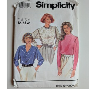 Peut inclure: Une pochette de patron de couture Simplicity intitulée Easy to Sew. Le devant présente des illustrations de trois hauts : un col en V bleu à pois, un haut à manches longues à motifs et un haut rose uni à col montant, portés avec des pantalons clairs.