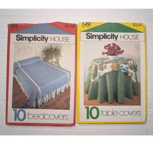 Könnte beinhalten: Zwei Vintage-Schnittmusterumschläge von Simplicity House. Der rote Umschlag mit der Nummer 122 zeigt eine blaue gesteppte Tagesdecke. Der gelbe Umschlag mit der Nummer 120 zeigt einen runden Tisch mit einer geblümten Tischdecke und einer grünen Tischhusse.
