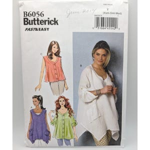 May include: Butterick sewing pattern B6056 for a loose-fitting top with a V-neckline, button front, and patch pockets. The envelope displays four variations of the top in white, coral, purple, and light green, with the text FAST & EASY printed.
