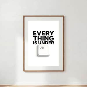 Könnte beinhalten: Ein gerahmter Kunstdruck mit dem schwarzen Text EVERY THING IS UNDER über einer weißen Computertastaturtaste mit der Aufschrift Ctrl. Das Kunstwerk ist in einem schlichten Holzrahmen mit weißem Passepartout präsentiert und bietet eine klare Komposition.