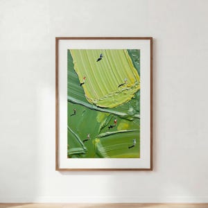 May include: A framed vertical wall art print featuring an abstract oil painting with thick, textured brushstrokes in various shades of green. Small, miniature figures of people are scattered across the surface, appearing to interact with the paint.