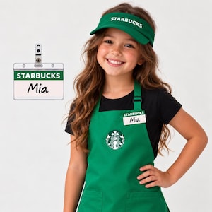 May include: A green Starbucks visor with white text, a green apron featuring the Starbucks logo and a name tag that reads Mia, and a separate clear plastic name badge holder with a green header labeled Starbucks and the name Mia printed below.
