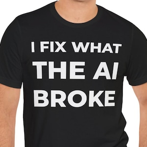 May include: A black short-sleeved t-shirt featuring the white text I FIX WHAT THE AI BROKE printed in a bold, sans-serif font across the chest. The garment has a classic crew neckline and a standard fit, providing a clean and simple appearance.