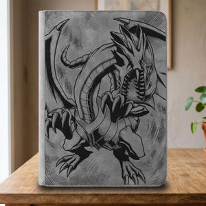 Pode incluir: Uma pasta retangular cinza com uma ilustração detalhada em estilo de tinta preta de um dragão com asas grandes, garras afiadas e boca aberta. O dragão é retratado em uma pose dinâmica com sombreamento de hachuras em todo o design.