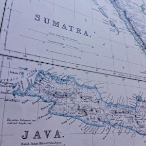 May include: An antique-style paper map featuring the islands of Sumatra and Java. The map displays geographical details, longitude lines, and scale bars. Text includes "SUMATRA" and "JAVA" with notes stating "The active volcanoes are colored bright red."