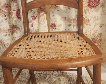 Silla vintage de madera de mediados de siglo con respaldo de escalera y asiento de mimbre.