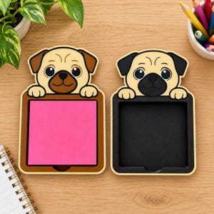 May include: Two pug-shaped memo holders with cartoon dog heads. The left holder is brown with a bright pink square notepad inside. The right holder is black with a matching black square interior. Both feature tan faces with dark ears.