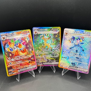 May include: Three collectible trading cards featuring Flareon ex, Leafeon ex, and Glaceon ex. Each card displays a 270 HP value, colorful holographic artwork, and detailed text including attack names like Burning Charge, Verdant Storm, and Frost Bullet.