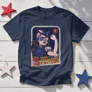 以下が含まれることがあります： ネイビーブルーのTシャツ。バンダナと星条旗柄のサングラスを着用した長髪の人物のグラフィックが描かれています。人物は腕の筋肉を見せるポーズをとっており、「PRIOR AUTHORIZATION SURVIVOR」という文字と赤いドル記号がデザインされています。