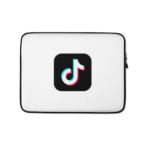 May include: A white rectangular laptop sleeve with black trim featuring a centered black square icon with rounded corners. Inside the square is a white TikTok musical note logo with cyan and magenta color shifts on the edges.