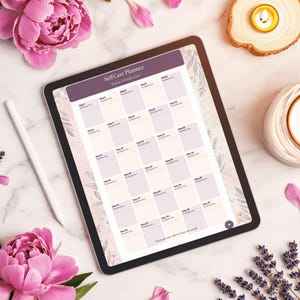 May include: A digital tablet displaying a Self Care Planner with a 30-day gratitude grid in shades of purple and cream. The screen features a floral border, and a white stylus rests beside the tablet. The interface includes text labels for each day.