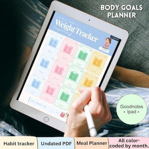 May include: A digital tablet displaying a Body Goals Planner with a Weight Tracker page. The interface features a grid of colorful cards with scale icons, text reading 12-Week Journey, and a small cartoon character. A stylus is held over the screen.