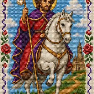 Puede incluir: Un bordado de punto de cruz que representa a una figura barbuda con túnica roja y capa morada montando un caballo blanco. La figura sostiene un bastón con una concha, lleva un sombrero con una concha y tiene un halo amarillo. Un castillo se alza al fondo, enmarcado por un borde de rosas rojas.
