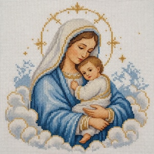 Puede incluir: Un bordado de punto de cruz que representa una figura con túnica azul y velo blanco sosteniendo a un niño pequeño vestido de blanco. Las figuras están rodeadas de nubes azul claro y un halo dorado sobre una tela de color blanco.