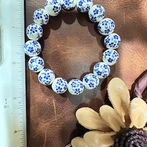 Rabatterat listpris gäller endast vid köp av matchande set med blå blommiga Mahjong-örhängen/armband. Mahjong, allihopa!