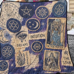 May include: A purple and blue quilt with a tarot card design. The quilt features a variety of symbols, including stars, moons, and crystals. The text on the quilt includes "The High Priestess", "The Star", "Dreams", and "Intuition".