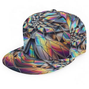 May include: A flat-peak cap with a geometric, iridescent pattern. The cap displays a repeating design of angular shapes in silver, yellow, purple, and blue. The brim and crown are fully covered in the colourful design.