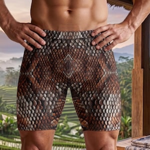 May include: Brown and tan snake skin pattern shorts. The shorts are part of the Venom Series - Aura Yoga collection. The background features a scenic view of rice terraces and mountains.