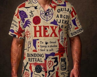 May include: A beige button-down shirt with a collage of occult symbols, including the word "HEX" in red, a Ouija board, and the words "BINDING RITUAL". The shirt features a variety of illustrations in red, purple, and black.