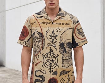 May include: A short-sleeve button-down shirt in a tan parchment colour featuring a black graphic print of a skull, a winged figure, a snake, and various occult symbols. The text "A whisper turned to ash" is printed across the upper chest area.