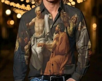 May include: A long-sleeve button-down shirt featuring a printed reproduction of a classical painting depicting figures in robes, paired with blue denim jeans. The shirt has a dark grey base color and a standard collar with a front button closure.