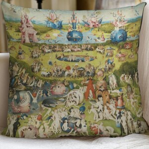 May include: Square throw pillow featuring a detailed, colorful painting with numerous figures and fantastical elements. The artwork depicts a vibrant landscape with a variety of scenes, set against a green and blue backdrop. The pillow is placed on a white couch.