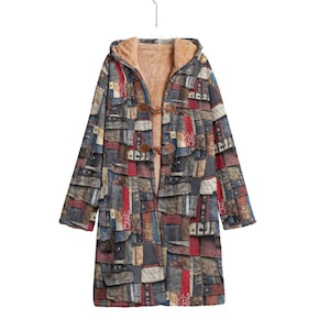 Puede incluir: Un abrigo largo con capucha y diseño de patchwork en tonos azules, rojos y grises. El abrigo presenta un cierre de palanca y un forro suave de color beige. El abrigo está colgado de una percha.