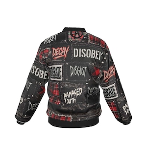 Puede incluir: Chaqueta bomber negra con parches con textos como "DISOBEY", "DECAY" y "DISGUST". La chaqueta tiene detalles de cuadros rojos y detalles de tachuelas metálicas. La chaqueta tiene cuello y puños negros.