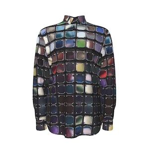 Puede incluir: Una camisa de manga larga con botones y un estampado geométrico colorido. El estampado está formado por cuadrados de diferentes colores y tonalidades, incluyendo azul, verde, morado y rojo. La camisa tiene un fondo negro y un cuello blanco.